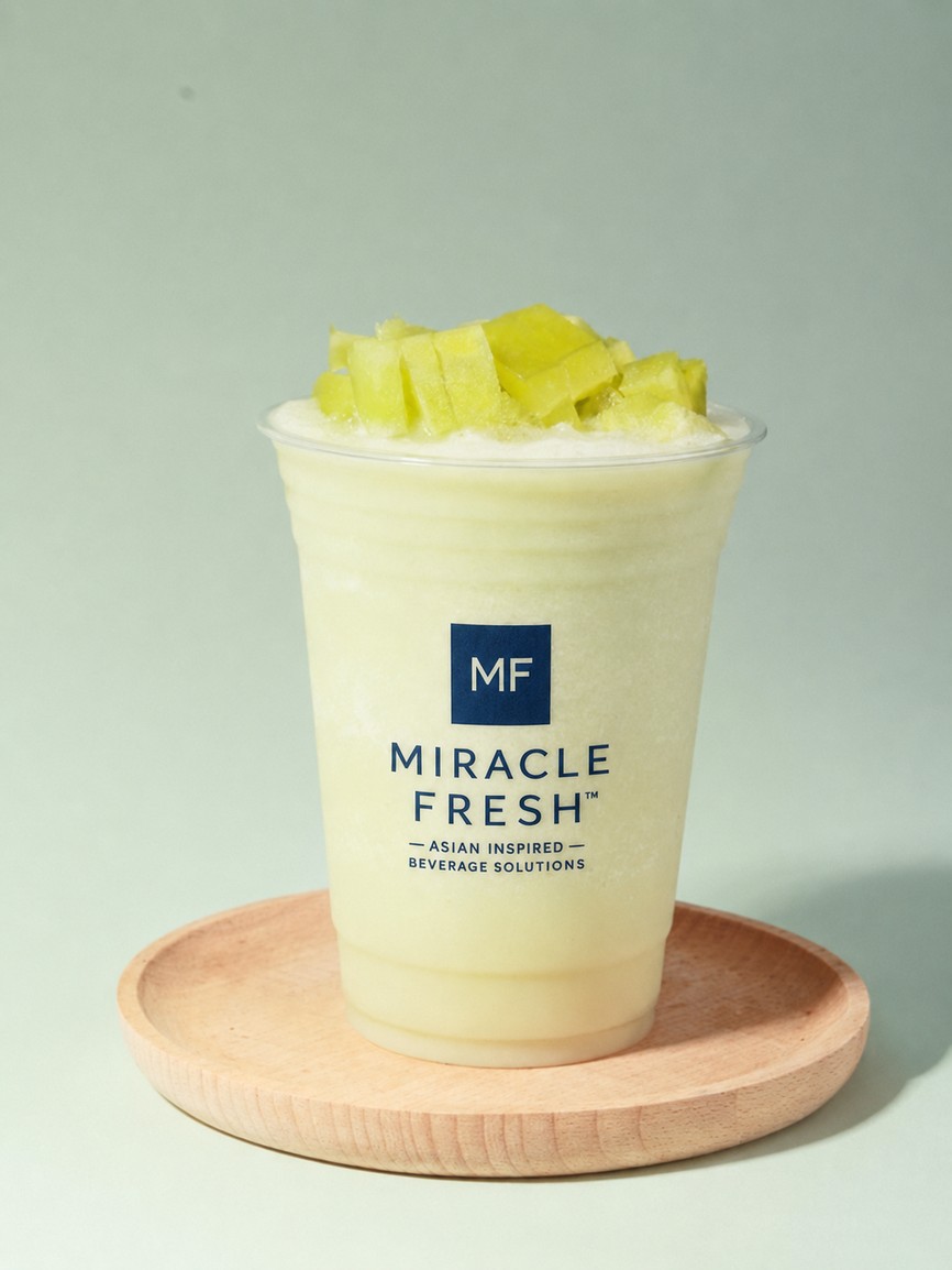 Muskmelon and coconut milk slush topped with yogurt cream on a wooden coaster