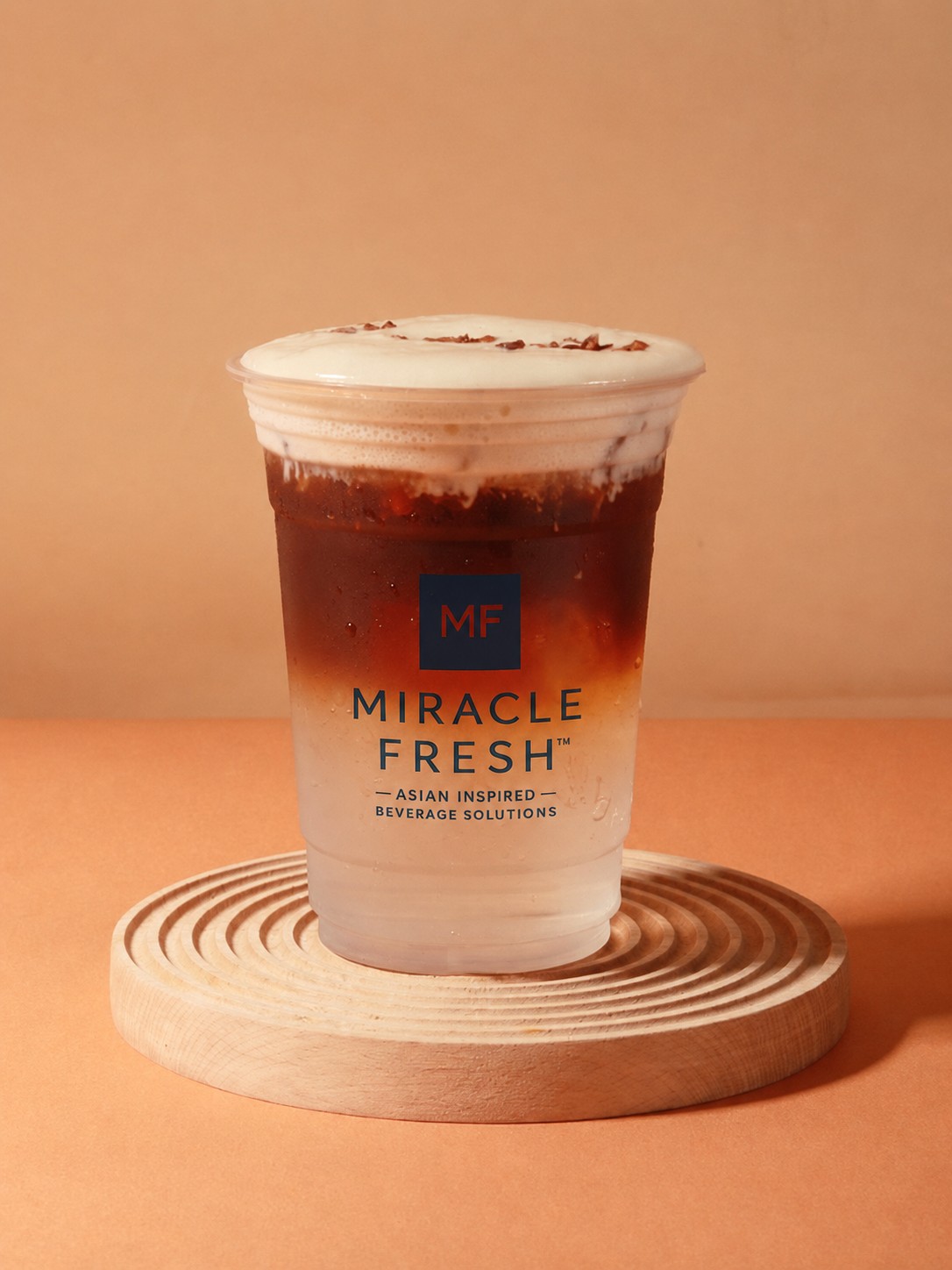 Layered coconut coffee topped with sour plum foam in a Miracle Fresh cup