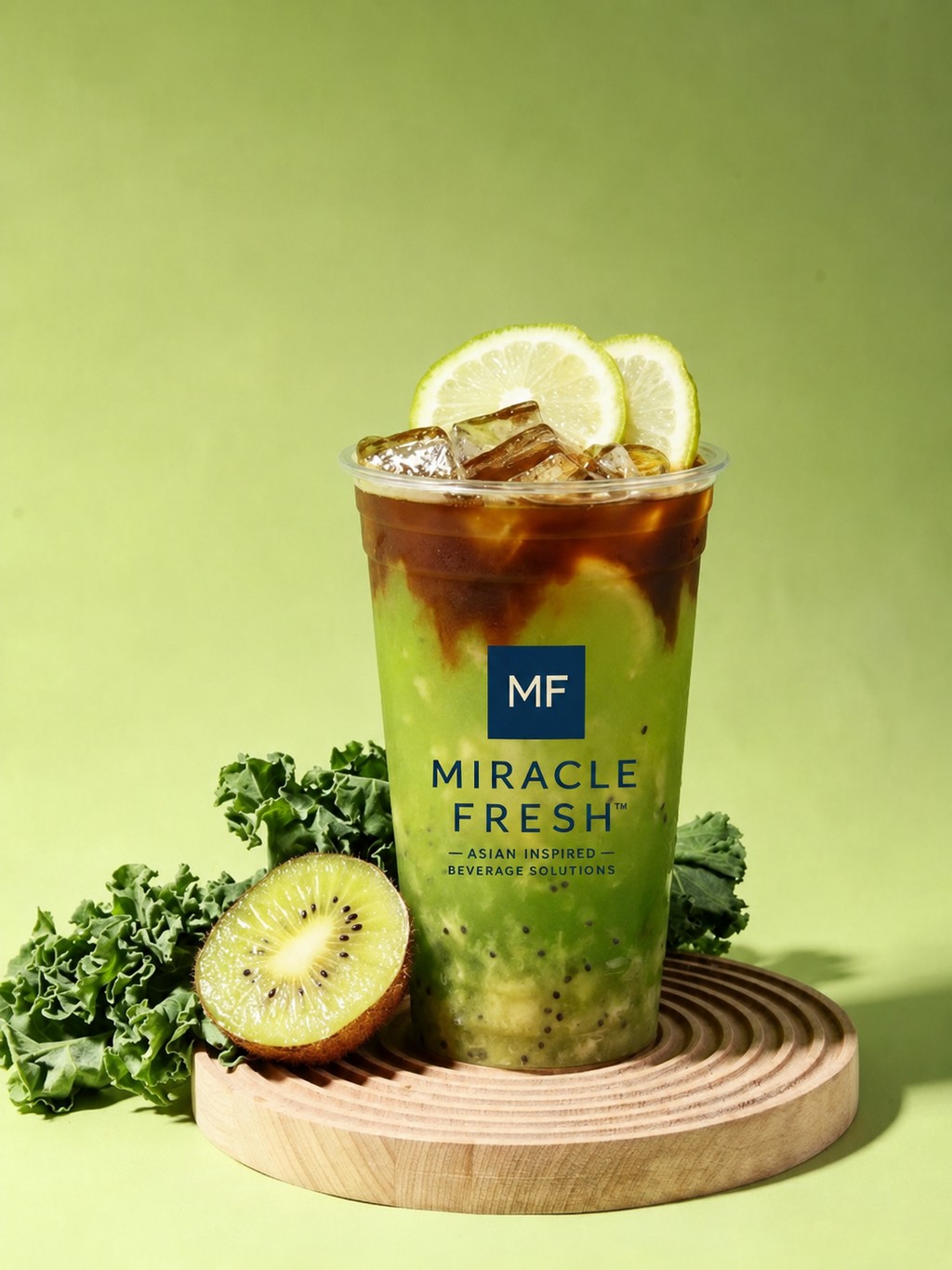 Layered kiwi green tea and espresso drink in a Miracle Fresh cup with fresh kiwi